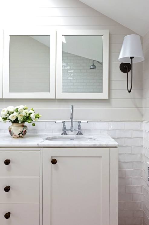 Black wood framed mirrors balance well with a white dual washstand Accented with antique brass knobs and off white quartz countertop
