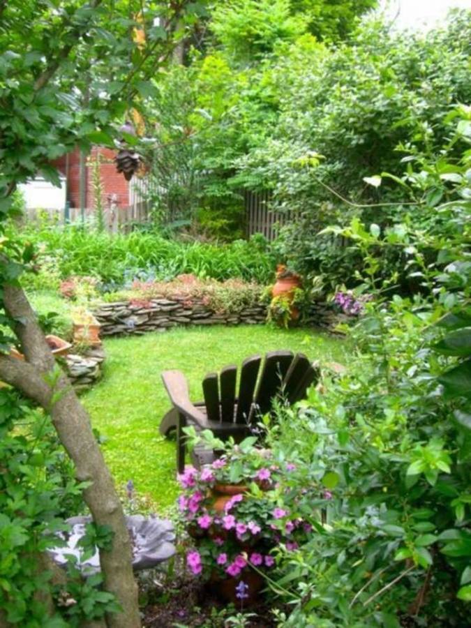 backyard with a fascinating fountain decorated with flowers and different types of plants