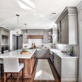 A kitchen cabinet section with open drawers showing glassware, plates and utensils